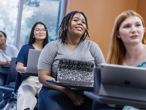 Students in a classroom, watching a lecture